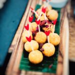 circa events canape menu salt cod croquettes on banana leaf with wooden board