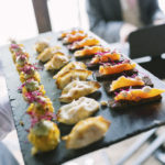 circa events canapes mix on a board of jungle sweetcorn cake vegan, pork gyoza and salmon on pumpernickel bread