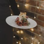 circa events starter option antipasti meats on a white plate with a fairylight background