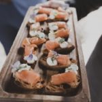 circa events canape option, smoked salmon on pumpernickel bread on a wooden board