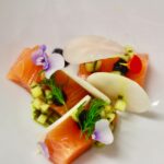 circa events bespoke starter cured salmon, edible flower, kolrabi sliced on a white plate