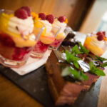 mini desserts on a board sharing style mini trifles, hazlenut parfaits on a wooden slate