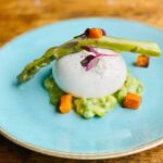 burrata starter on blue plate with fresh asapargus with wooden background